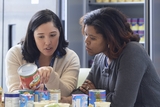 Two ladies are checking the can's label.