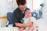 Nurse helping baby with complex airway issues to sit up