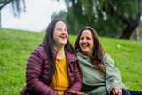 Girl with Down Syndrome laughing with her mom