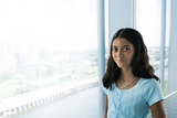 Young teen standing in front of the window smailing