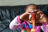 Child using inhaler with help of adult