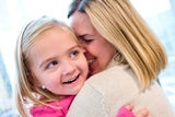 Mother and daughter hugging and smiling