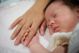 Infant holding onto finger