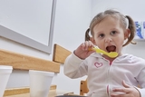 Young girl eating with a spoon