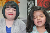 Two girls smiling with new haircuts