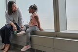 Doctor talking to child next to window