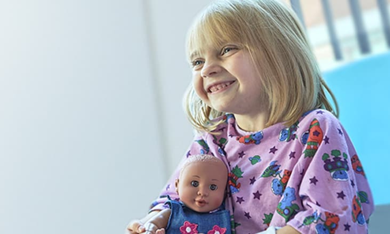 Young hospital patient clutching doll