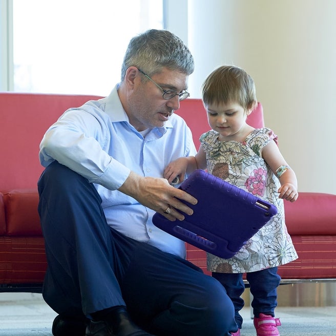 Doctor showing something on a tablet to a young girl