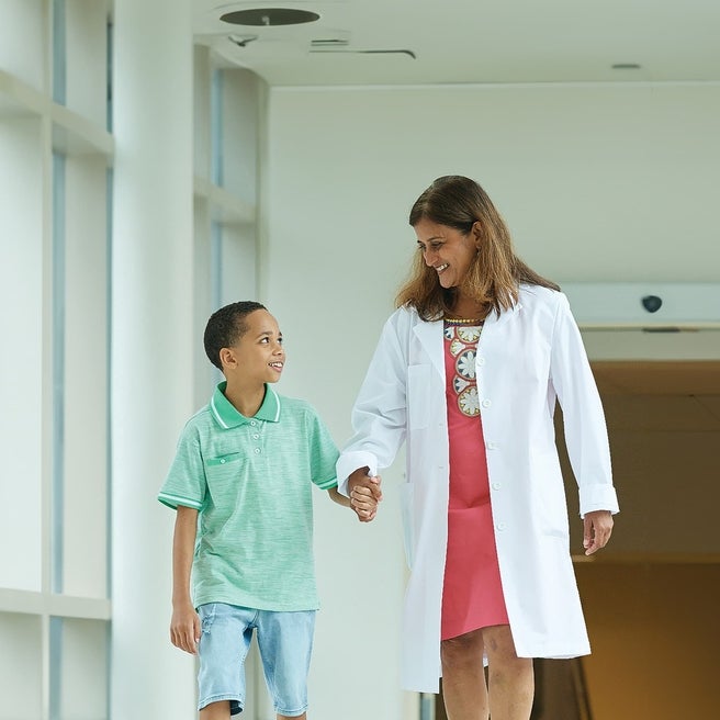 Physician walking down a hallway with her patient