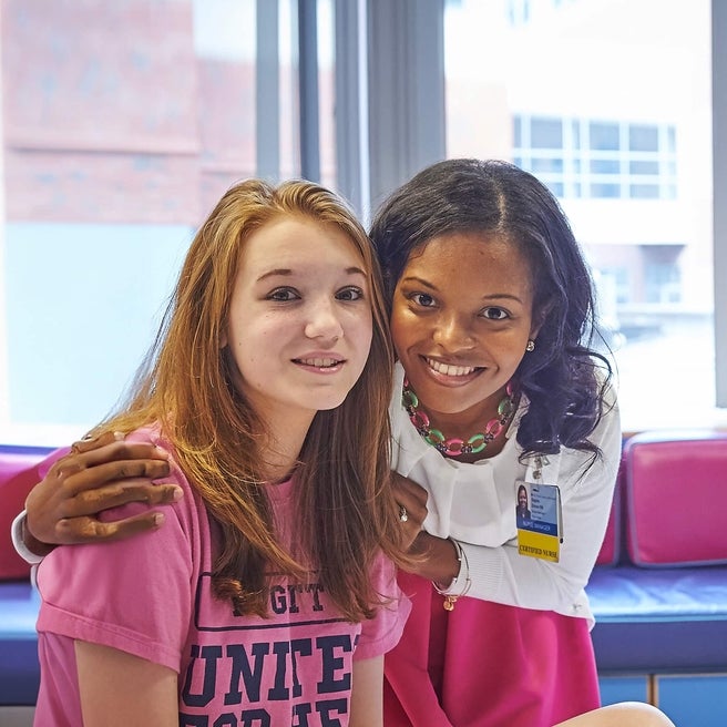 Nephrology team member placing her hands on the shoulders of one of her patients