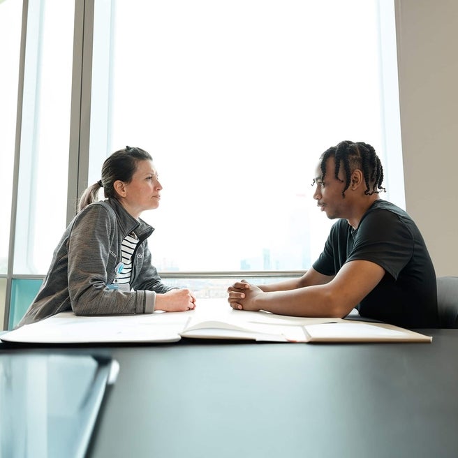 physician and doctor talking at a table