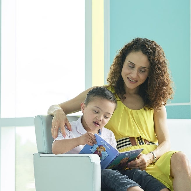 Woman reading book to young boy