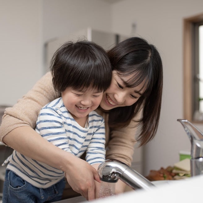 Mom teaching child to wash hands