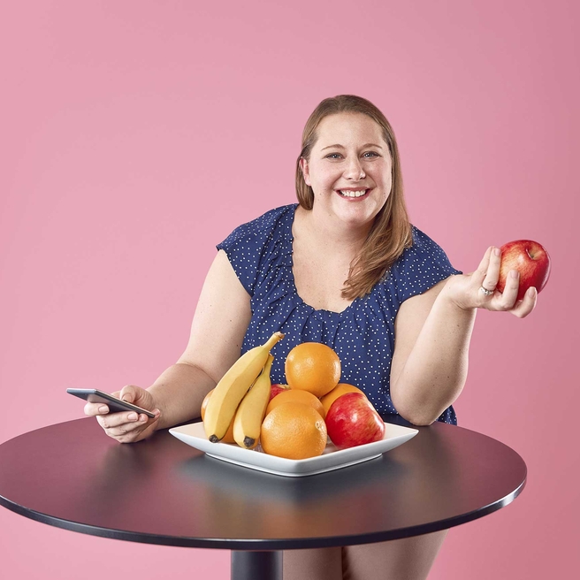 Dietician smiling with a bowl of fruit.