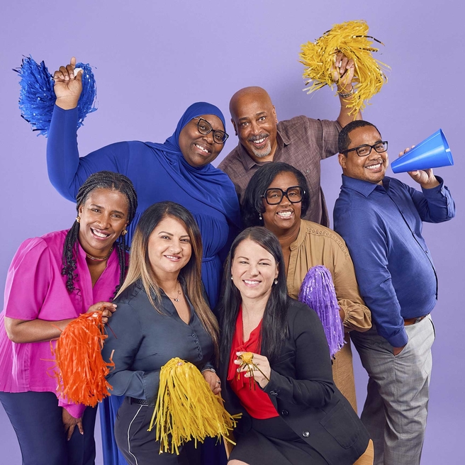 A group of Environmental Services staff cheering with pom poms.