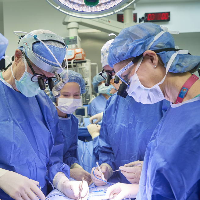 A surgical team in the operating room surrounds a fetal surgery patient