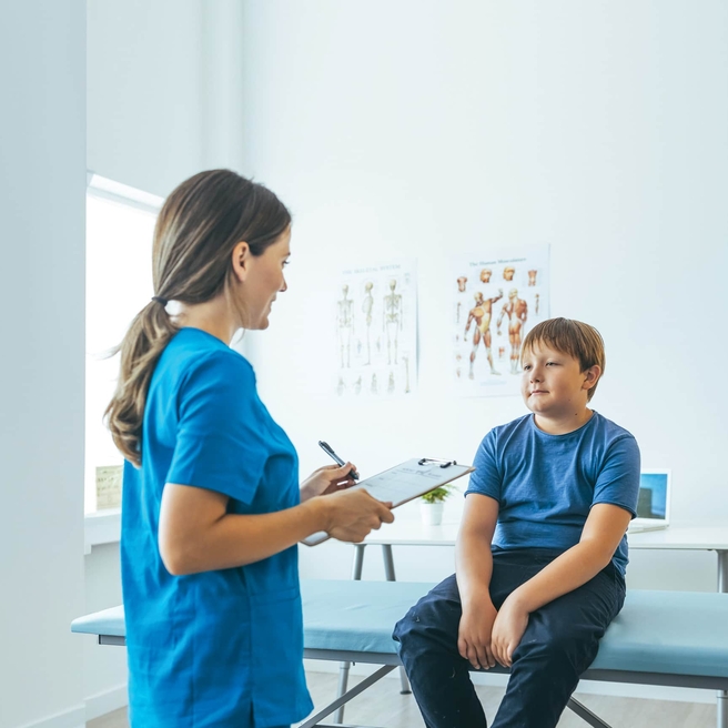 Young teen in exam room with physician