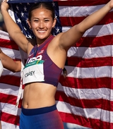 Annie, a CHOP patient and Paralympian for Team USA, holds an American flag in her uniform.