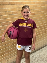 Maeve holding a basketball in uniform