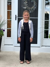 Maeve stands on her front steps wearing her backpack ready for 3rd grade