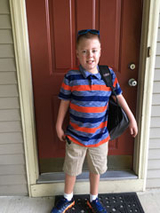 Chad standing outside front door with his backpack