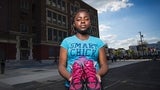 Teenage girl holding a pair of sneakers