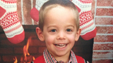 Noah smiling in front of fireplace