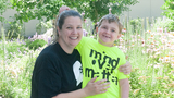 Sam standing outside of CHOP with his mom at Age 5