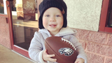 blonde hair boy holding football smiling