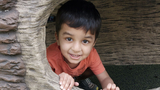 Zaki playing in a fake rock cave