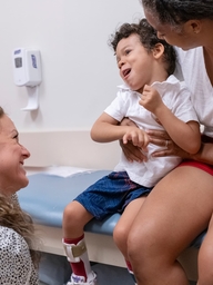 Emma McKenzie, a physical therapist in the Seating Clinic, greets Apollo, 4, who has cerebral palsy, and his mother, Lesana.