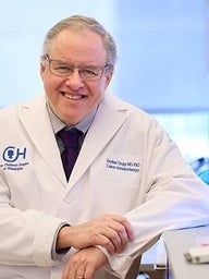 Dr. Grupp wearing a white coat in a lab