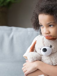 Scared young girl holding a stuffed animal