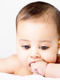 Teething baby chewing on hand