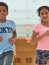 Young boy and girl running down hall