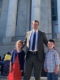 Father standing outside a courthouse with his children