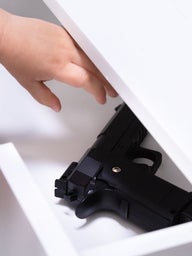 little girl reaching for gun in drawer