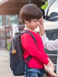 Mother with son holding backpack