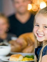 Young girl smiling at Thanksgiving table