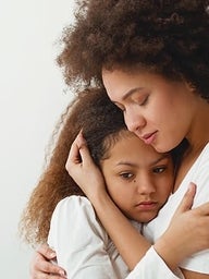 Mother hugging distraught daughter