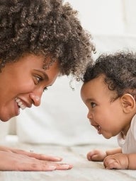 Mother playing with young toddler on the floor