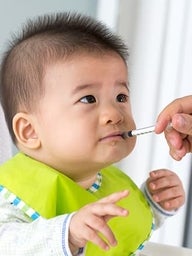 Young baby taking oral injection medicine