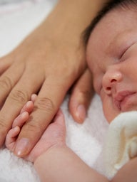 Infant holding onto finger