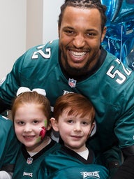 Najee Goode poses with kids at the 8th annual Huddle Up for Autism