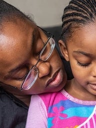 Mother holding daughter close