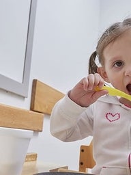 Young girl eating with a spoon