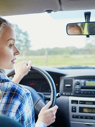 Female teenager behind the steering wheel of a car