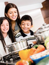 Family in kitchen cooking healthy meal together