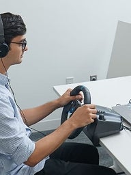 Teenager using a steering wheel for a safe driving simulator