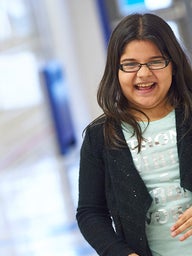 Young girl in hallway smiling